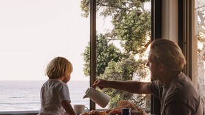 Un espace repas avec vue sur la mer, une table ronde et des chaises.
