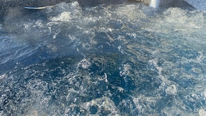 A hot tub with bubbling water, surrounded by a stone wall and a wooden deck. - Newly remodeled, Hot Tub, 70n inch tv Private Entrance, Convenient location (Lebanon)