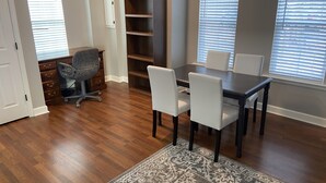 A dining area with a dark wooden table, white chairs, and a patterned rug. - Newly remodeled, Hot Tub, 70n inch tv Private Entrance, Convenient location (Lebanon)
