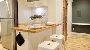 A modern kitchen with a built-in island, stainless steel refrigerator, and wooden flooring.