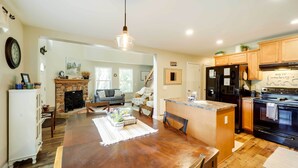 A spacious kitchen with wooden cabinets, a central island, and a built-in oven. - 'Greystone' Creekside Cabin: Hike, Fish & Explore! (Elk Park)