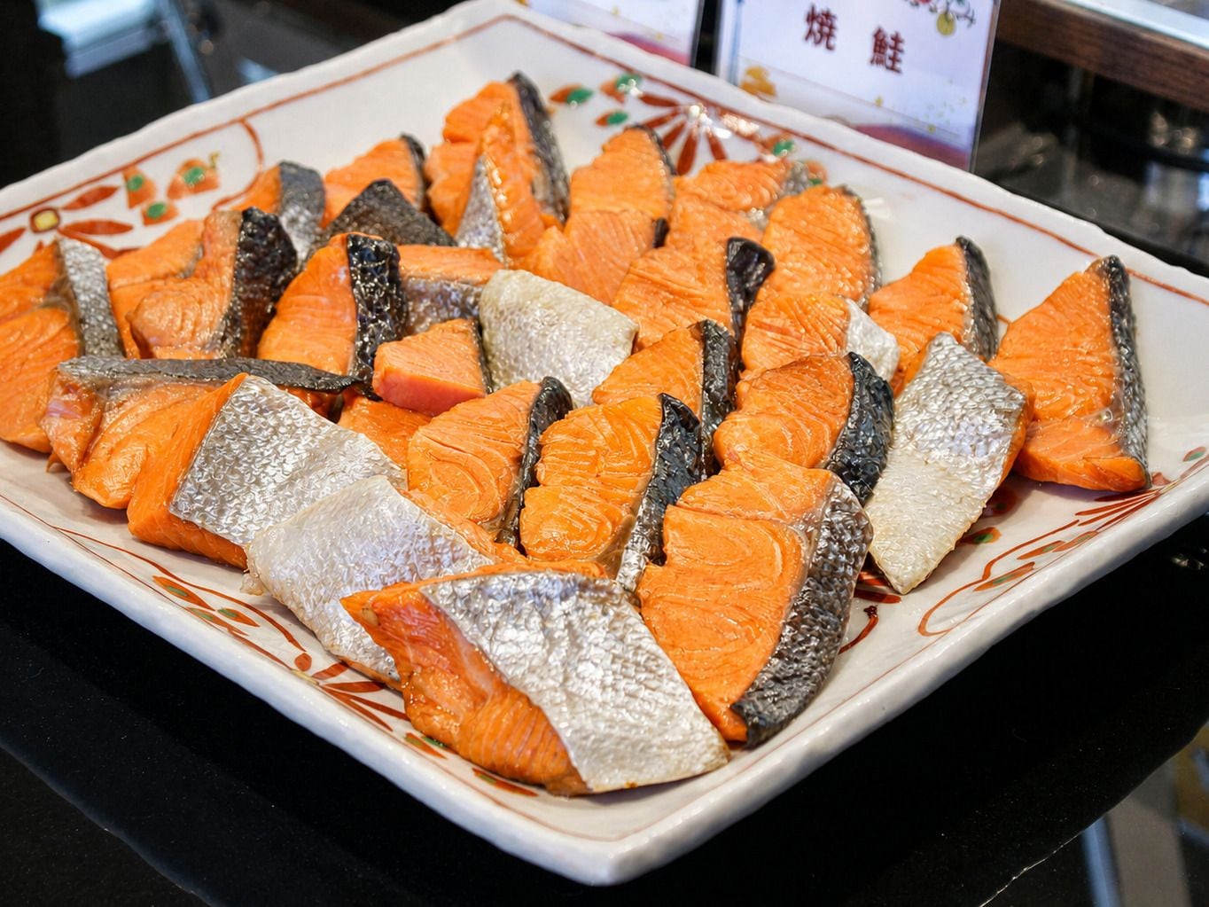 A plate of sliced fish, likely salmon, arranged neatly on a decorative plate.