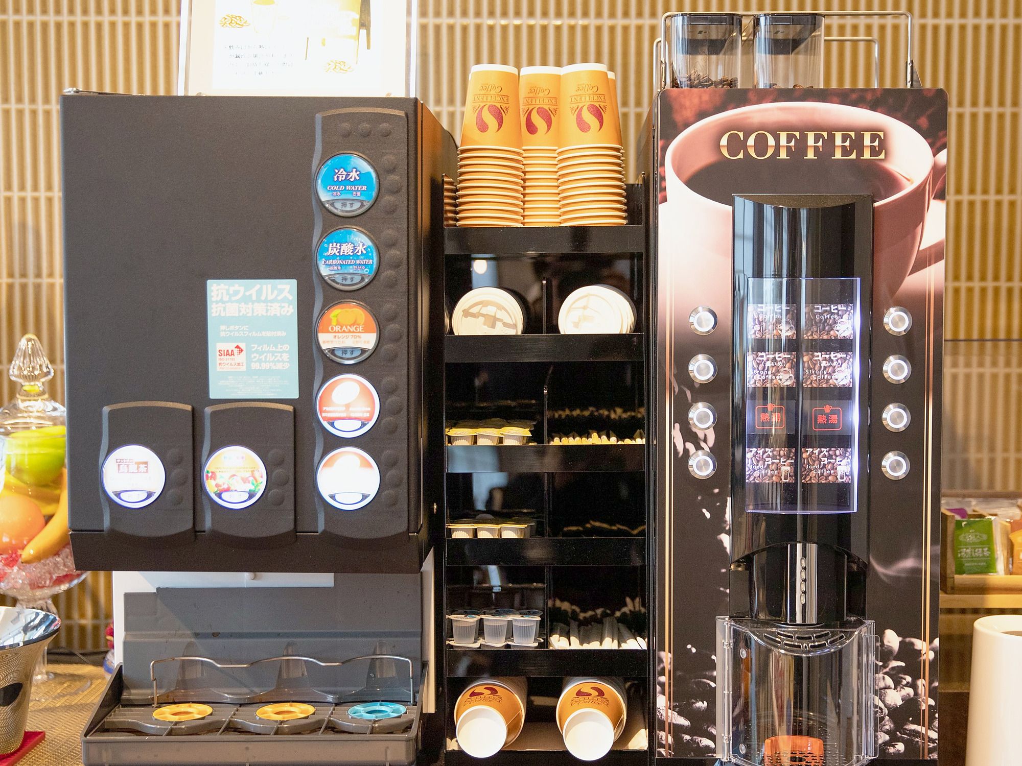 A coffee machine with multiple dispensers, including options for cold water, carbonated water, and various coffee types.