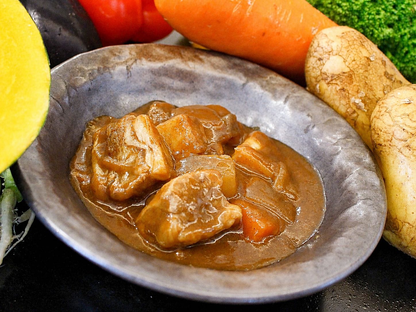 A plate of food with a sauce, surrounded by vegetables.