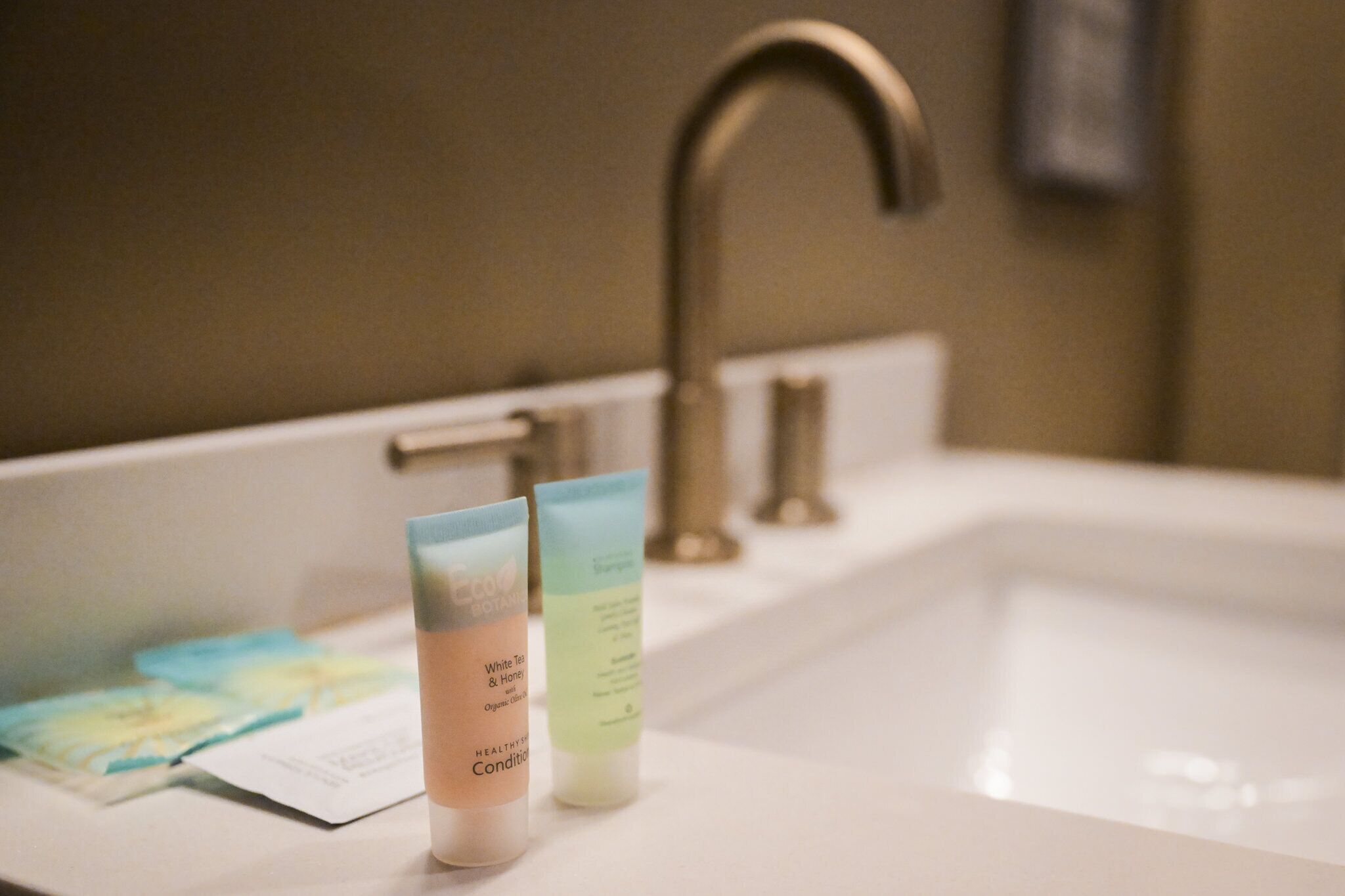 A bathroom sink with two toiletry bottles and a paper towel.