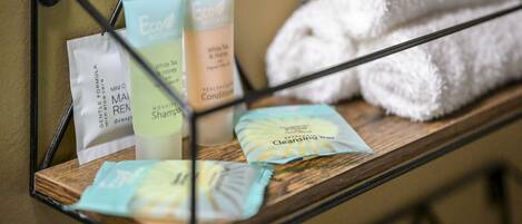 A shelf with various skincare products, including a cleansing bar and a white tea and honey conditioner.