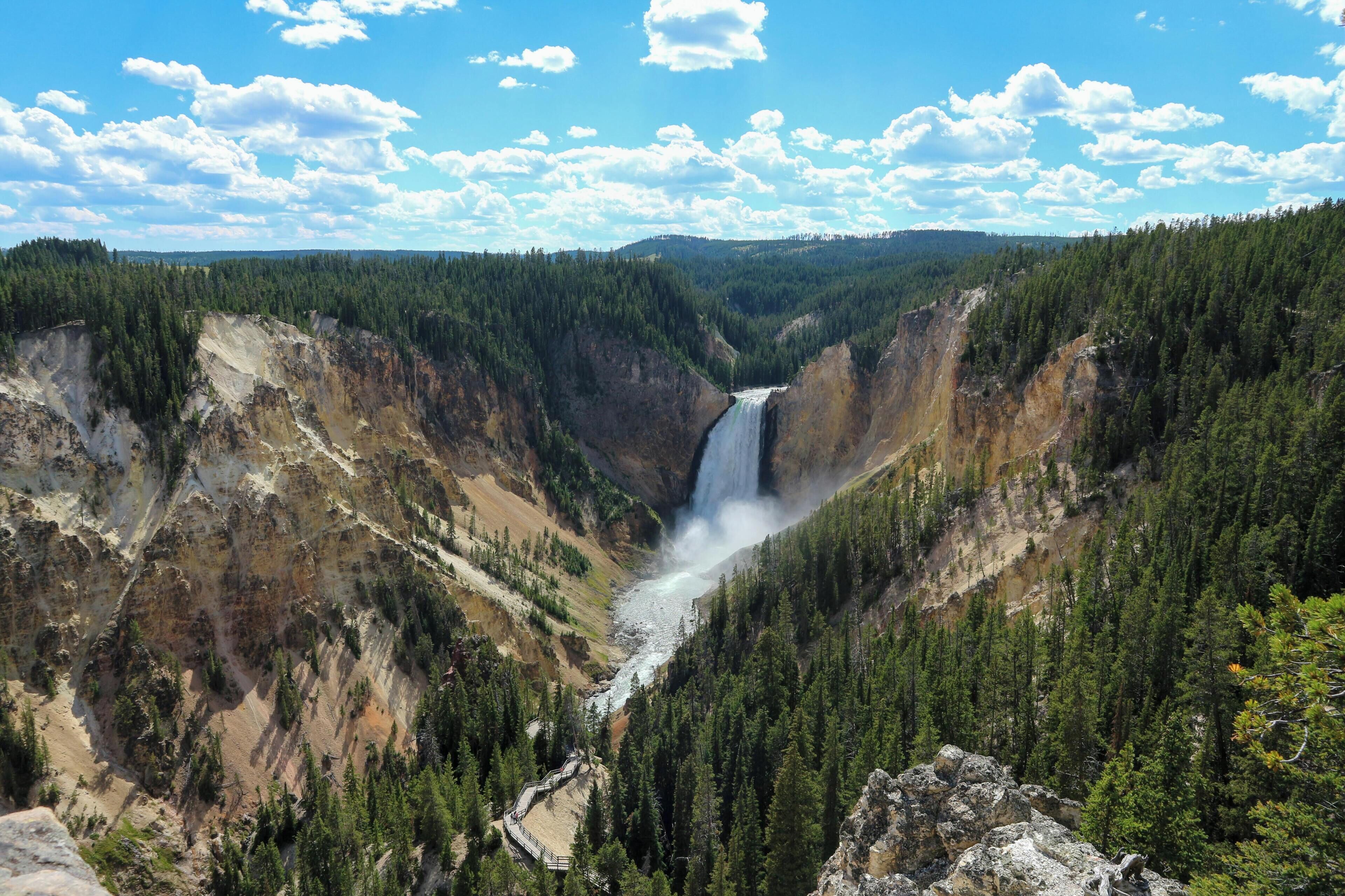 Een canyon met een waterval, dicht bos en rotsachtig terrein.