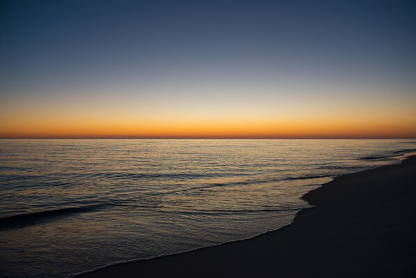 A beach with a clear sky and calm sea.