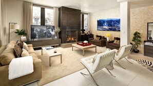 Una sala de estar moderna con chimenea, un televisor grande y asientos cómodos.