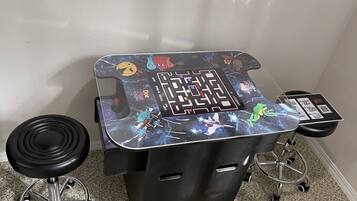Une table de jeu avec un jeu de labyrinthe, un tabouret et une chaise.