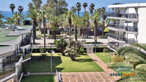 Un hôtel doté d’une piscine sur le toit, de palmiers et offrant une vue sur l’océan.