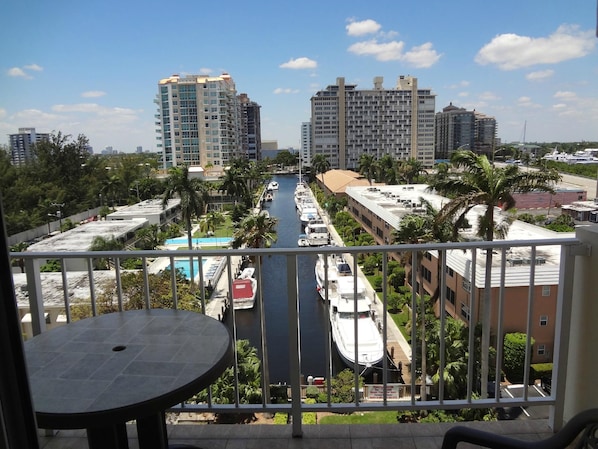 A high-rise building with a view of a marina and a pool.