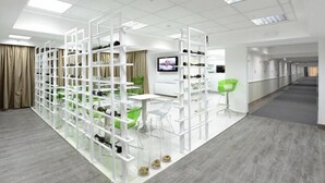 A modern office space with white shelving units, a green chair, and a desk. - Ibis Styles Skopje (Skopje)