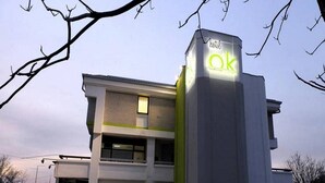 A building with a prominent 'ok' sign on the facade, suggesting it is a hotel. - Ibis Styles Skopje (Skopje)