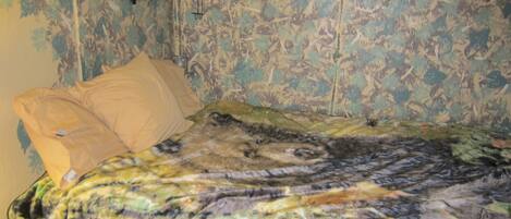 Ein Bett mit floralem Muster auf der Bettdecke und zwei Kissen.