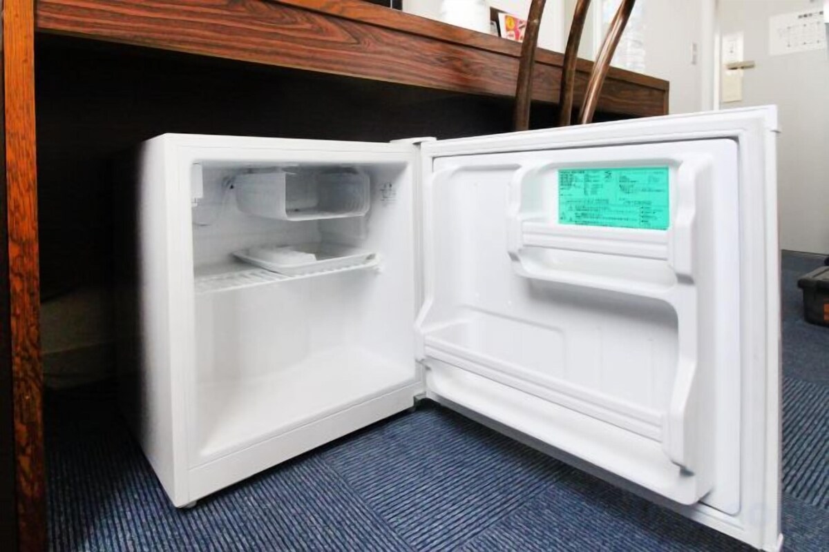 An open refrigerator with a digital display, a shelf, and a drawer.