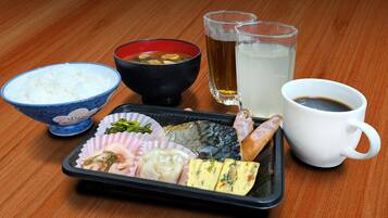 Bandeja de comida con arroz, sopa y varios platos, acompañada de dos vasos de agua y una taza de café sobre una mesa de madera.