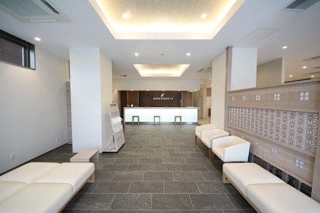 A modern reception area with a reception desk, seating area, and a patterned wall.