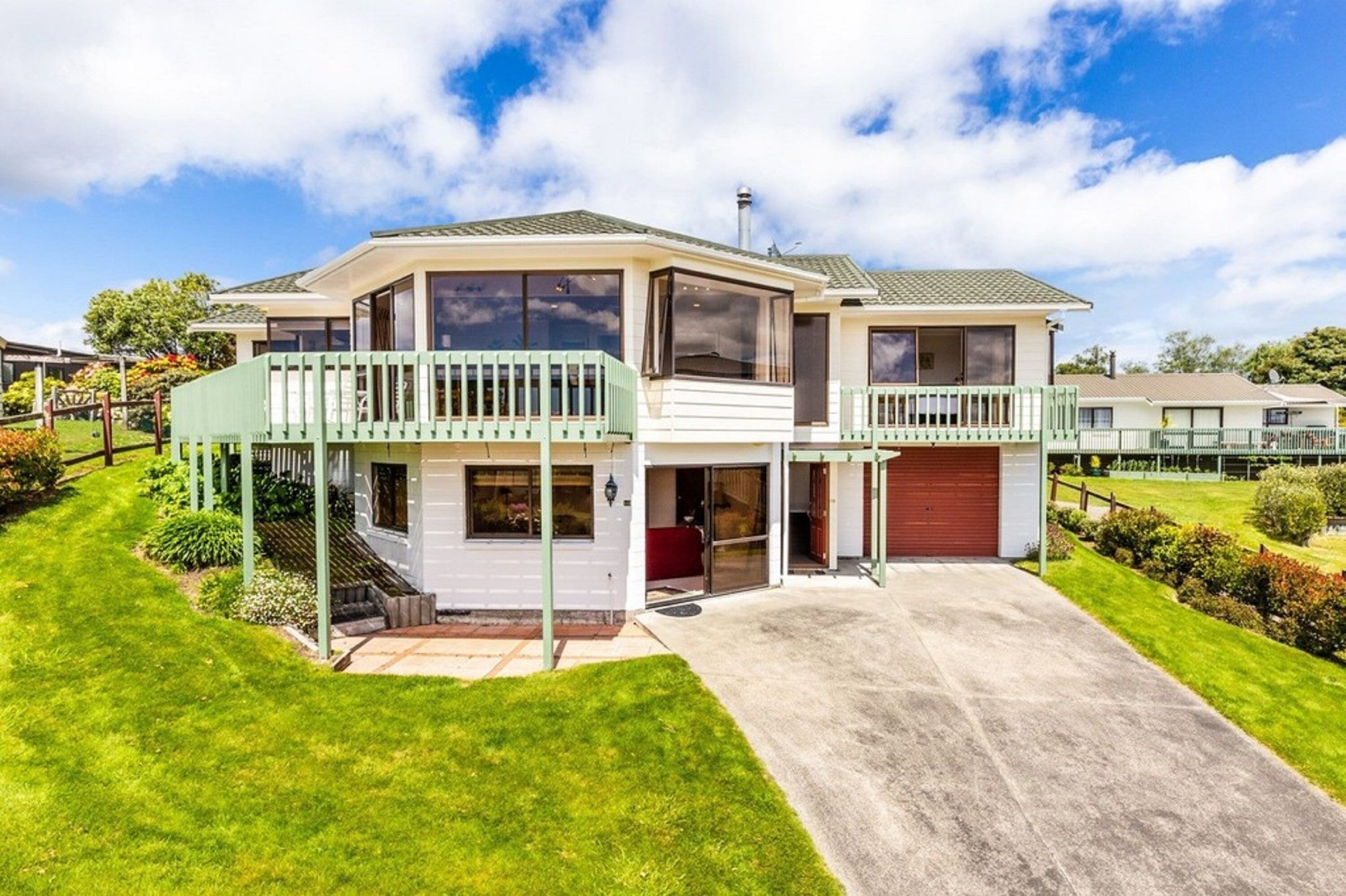 A two-story house with a covered porch, a garage, and a well-maintained lawn.