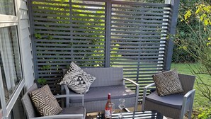 Een terras met een bank, twee fauteuils en een salontafel.