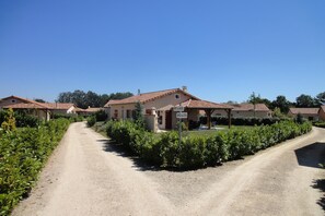 A rural road leading to a row of houses with a gravel path. - Luxury Villa in France with Private Pool (Les Forges)