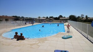 A swimming pool with people swimming and lounging. - Luxury Villa in France with Private Pool (Les Forges)
