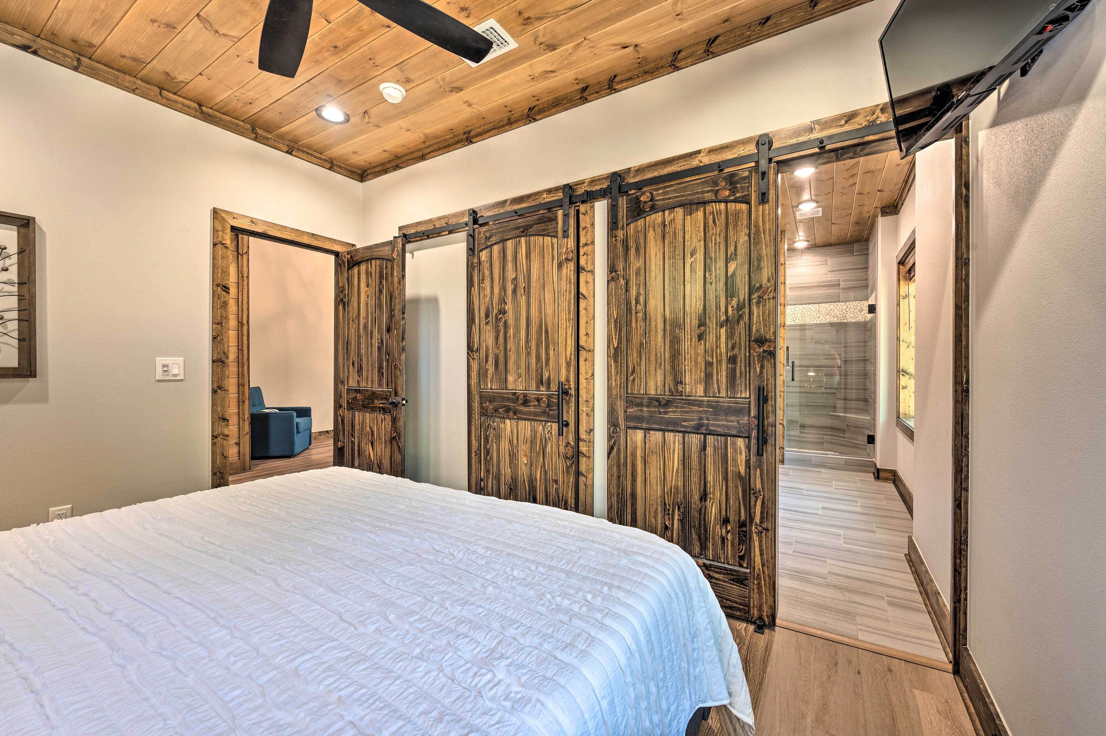 A bedroom with a large bed, wooden wardrobe, and a staircase leading to another room.
