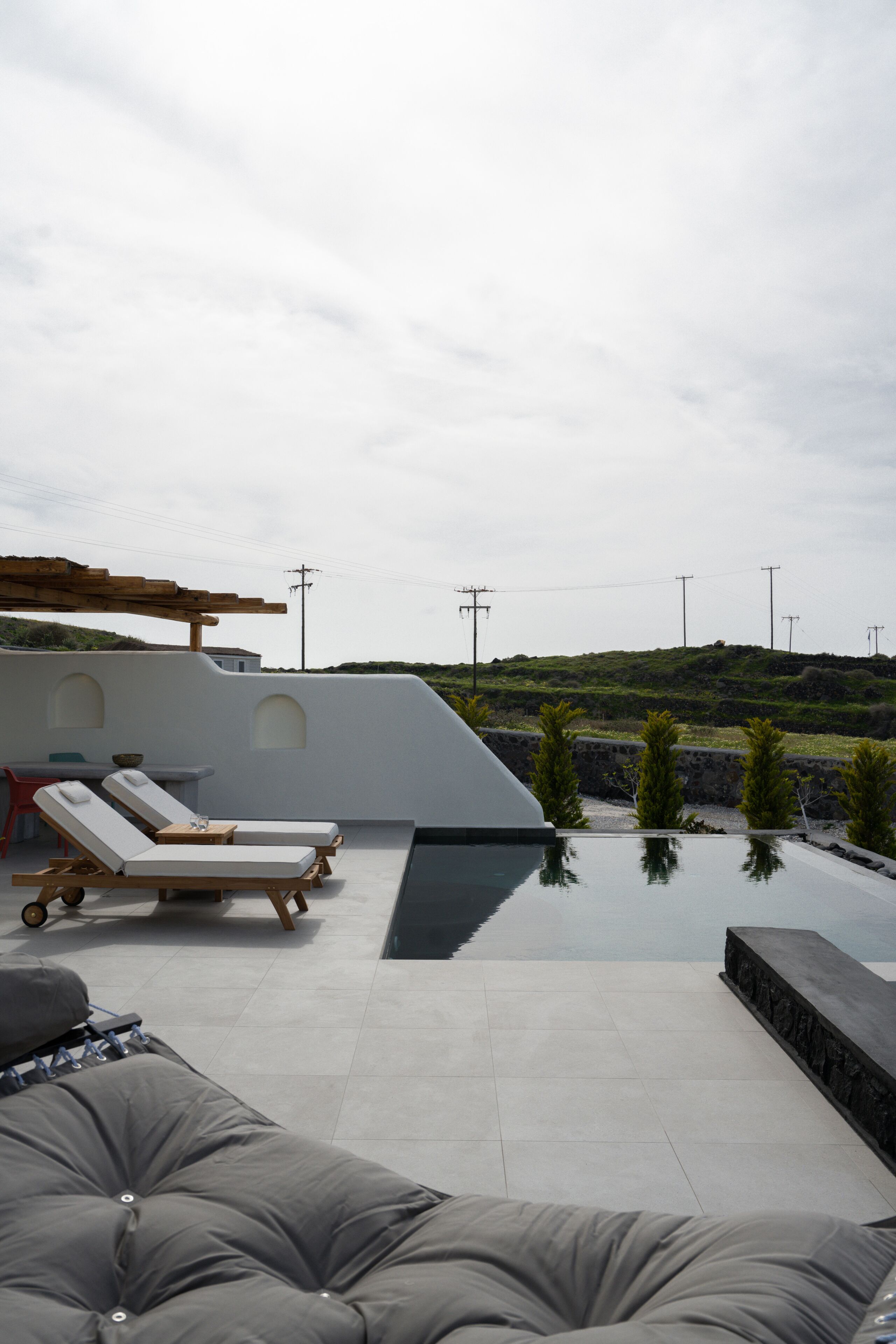Ein Außenbereich mit Infinity-Pool, Liegestühlen und einer modernen Lounge.