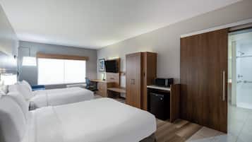 Habitación de hotel con dos camas, un escritorio, televisión, microondas y zona de ducha.