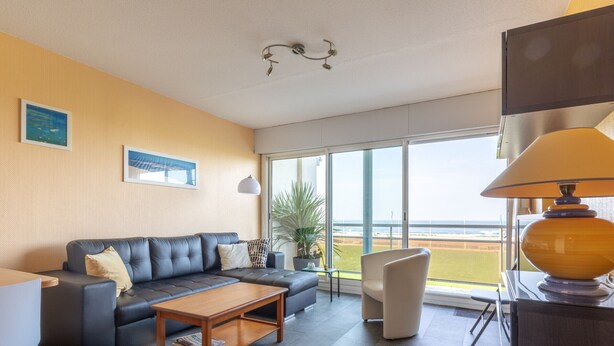A modern living room with a sofa, coffee table, and a view of the beach through large windows. - T2 Apartment Biscarrosse - AC, Parking, 4 guests, City Center (Biscarrosse Plage)