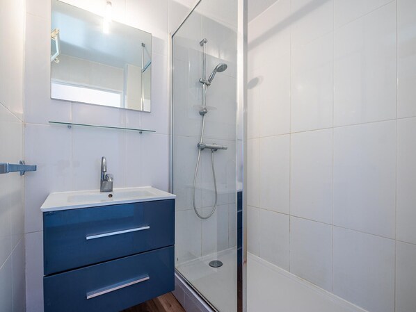 A bathroom with a glass shower enclosure, a white sink, and a blue vanity with drawers. - 2⭐ apartment with terrace and beach view in Sète - 6 people (Sète)