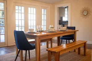 A dining area with a wooden table, blue chairs, and a bench.