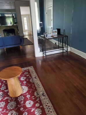A living room with a blue sofa, a wooden coffee table, and a patterned rug.