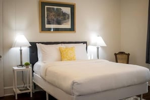 A hotel room with a bed, two bedside lamps, a framed picture on the wall, and a small table with a plant. - Mins to ASU & Downtown- Foxy on Felder (Montgomery)