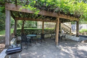 A wooden pergola with a table and chairs underneath, surrounded by greenery. - Mins to ASU & Downtown- Foxy on Felder (Montgomery)