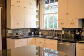 A kitchen with white cabinets, a black countertop, a window, and a sink. - Mins to ASU & Downtown- Foxy on Felder (Montgomery)