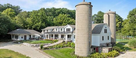 A large estate with two prominent cylindrical silos, a main house, and a smaller structure.