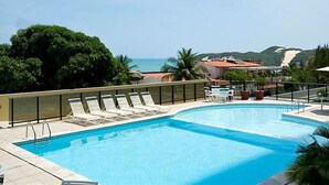 A swimming pool with lounge chairs and a view of the sea. - Dune& Ocean Views Paradise 2 Beds in Natal (Natal)
