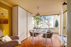 A dining area with a table and chairs, a hanging light fixture, and a view of the outside. - Playa Canela I - Punta del Moral Beach PPHC36P36 (Punta del Moral)