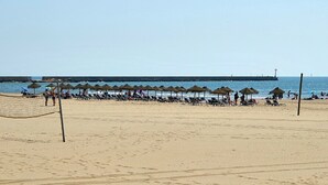 A beach with a volleyball net, sun loungers, and umbrellas. - Playa Canela I - Punta del Moral Beach PPHC36P36 (Punta del Moral)