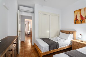 A hotel room with a bed, bedside table, and a painting on the wall. - Playa Canela I - Punta del Moral Beach PPHC36P36 (Punta del Moral)