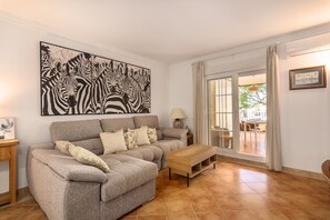 A living room with a grey sofa, a wooden coffee table, and a large zebra print artwork on the wall. - Playa Canela I - Punta del Moral Beach PPHC36P36 (Punta del Moral)