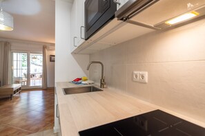 A modern kitchen with a built-in microwave, a sink, and a stainless steel faucet. - Playa Canela I - Punta del Moral Beach PPHC36P36 (Punta del Moral)