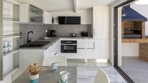 A modern kitchen with white cabinetry, a built-in oven, and a large window. - PLAYA VISTA MAR DUPLEX APARTMENT (El Port de la Selva)