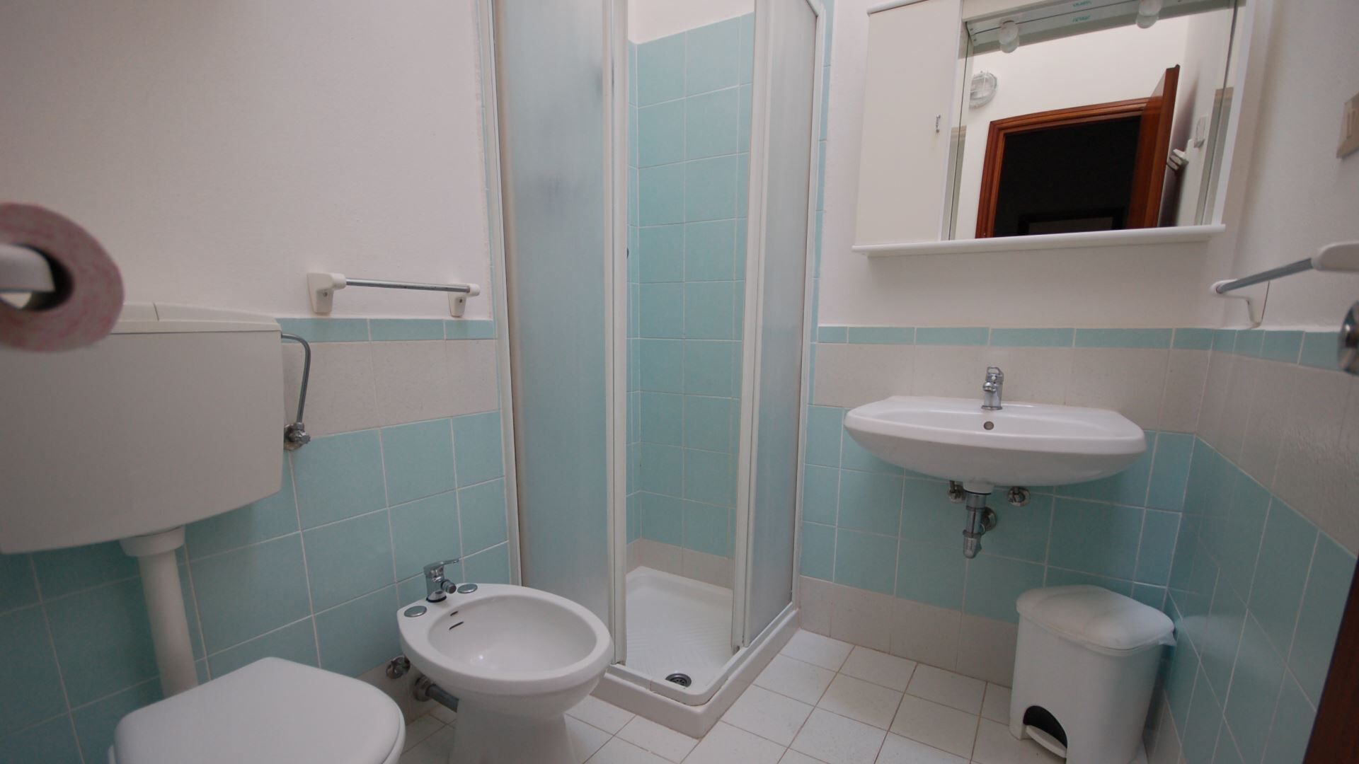 Une salle de bain comprenant des toilettes, un bidet, un lavabo et une douche.