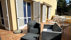 An outdoor patio with wicker furniture, including chairs and a table, and a tiled floor. - Delta Blu Residence Village - Appartamento Quadrilocale 2 (Lido di Pomposa)