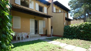 A two-story house with a covered patio, a small garden, and a white fence. - Delta Blu Residence Village - Villetta Trilocale 19 (Lido di Pomposa)
