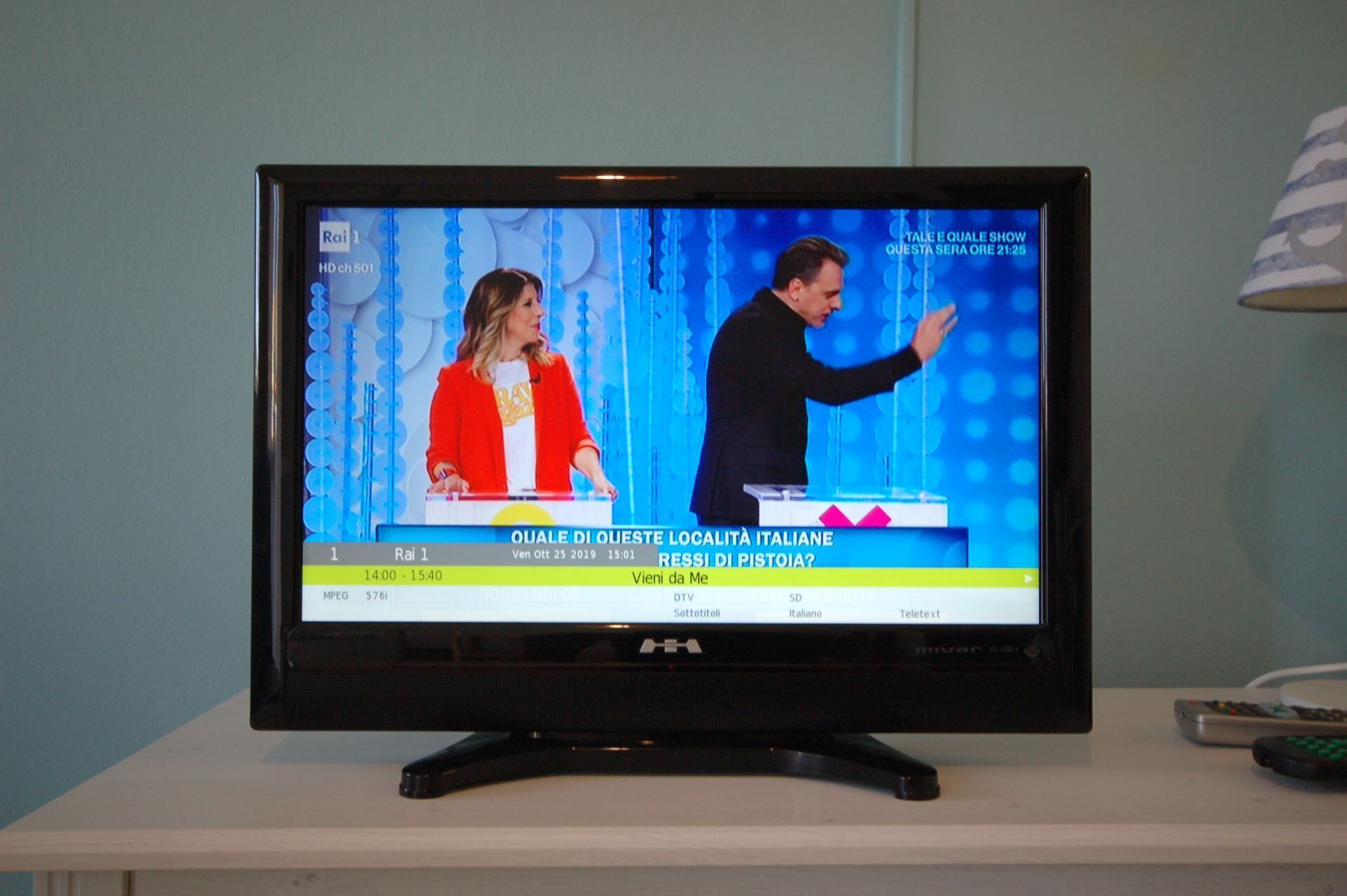 A television displaying a news program with a blue background and a presenter.