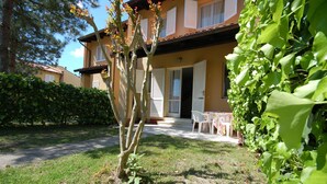 Un edificio a due piani con un giardino antistante.