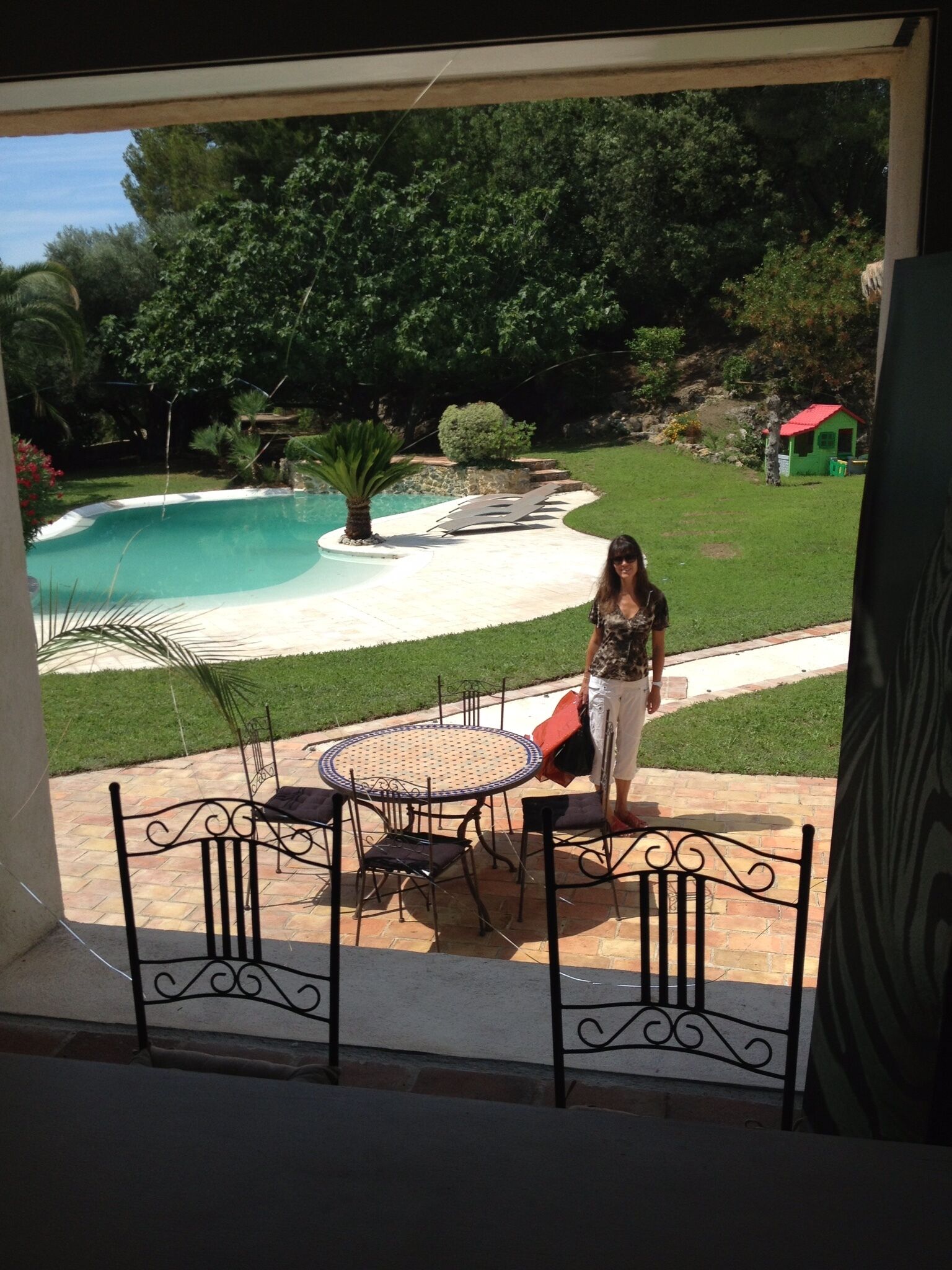 A patio with a pool, a small table, and chairs.